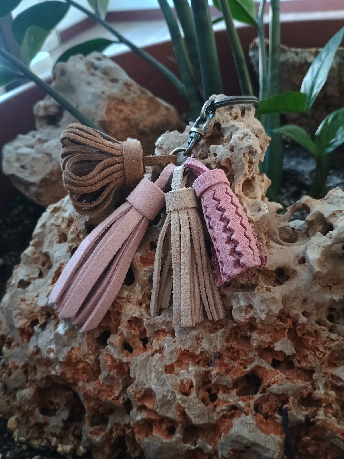 Llavero de piel natural hecho a mano diseño clásico con flecos sobre piedra