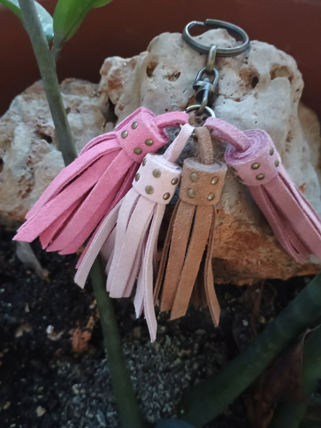 Llavero de piel artesanal diseño encanto tonos rosas sobre piedra