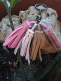 Llavero de piel artesanal diseño encanto tonos rosas sobre piedra